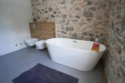 a bathroom with a white bath tub and a toilet at Vila Mirko in Kotor