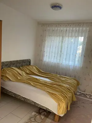 a bed in a room with a window with a yellow blanket at Apartmani Arieta in Donji Štoj