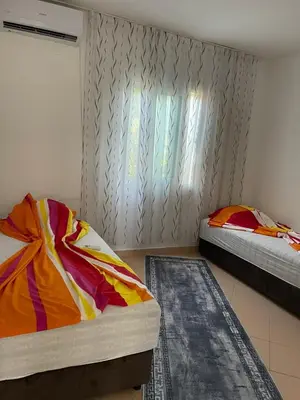 a bedroom with two beds and a window and rug at Apartmani Arieta in Donji Štoj