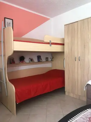 a bedroom with two bunk beds and a red bed at Apartmani Marina Sutomore in Sutomore