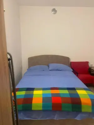 a bed with a colorful blanket on top of it at Apartmani Marina Sutomore in Sutomore