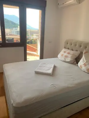 a bed in a room with a large window at Anatolia in Becici