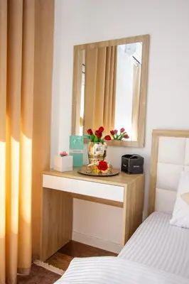 a bedroom with a table with a mirror and a bed at Apartment Numa - Ulcinj in Ulcinj