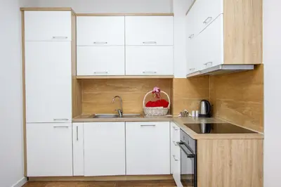 a kitchen with white cabinets and a sink at Apartment Numa - Ulcinj in Ulcinj
