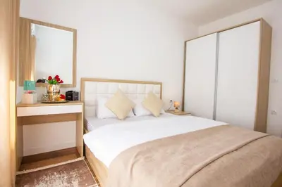 a bedroom with a large white bed with two windows at Apartment Numa - Ulcinj in Ulcinj