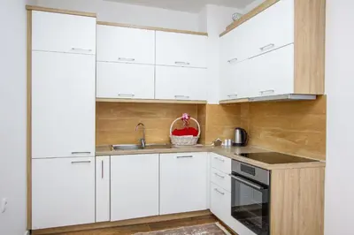a kitchen with white cabinets and a sink at Apartment Numa - Ulcinj in Ulcinj