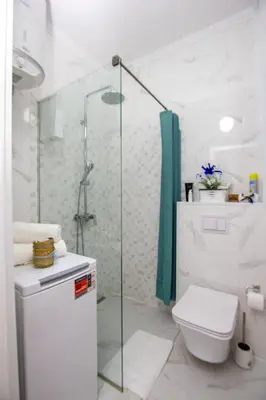 a white bathroom with a shower and a toilet at Apartment Numa - Ulcinj in Ulcinj