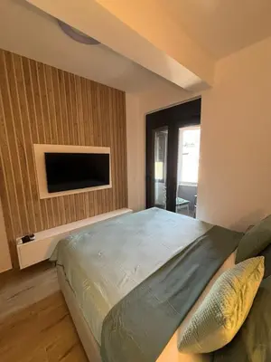 a bedroom with a bed and a flat screen tv at Una Dobra Voda in Dobra Voda