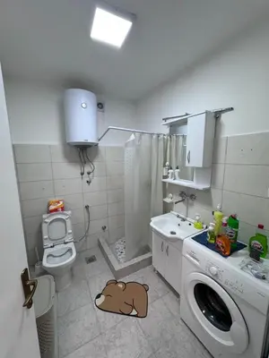 a bathroom with a washing machine and a toilet at Ulcinja Apartment Pinjes in Ulcinj