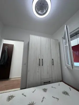 a bedroom with a bed and a cabinet and a window at Ulcinja Apartment Pinjes in Ulcinj