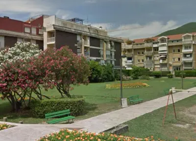 a park with benches and buildings in a city at Itana by the sea in Budva