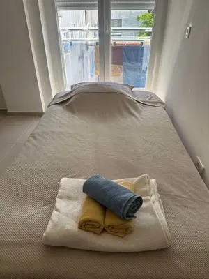 a bed with two towels on a bed with a window at Tara in Bar