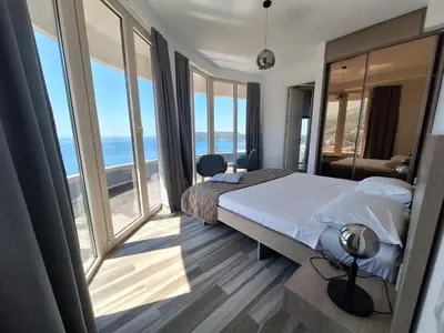 a bedroom with a bed with a view of the ocean at Skyline sea view apartment in Becici
