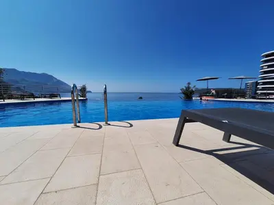 a bench sitting in front of a swimming pool at Skyline sea view apartment in Becici