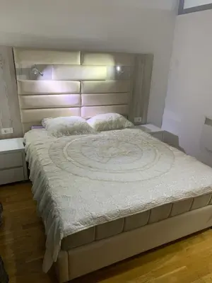 a bedroom with a large bed with a headboard at Disa&Nuzi in Ulcinj