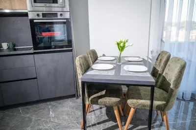 a kitchen with a table with chairs and a microwave at Urban Nest Apartment in Ulcinj
