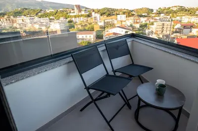 two chairs and a table on a balcony at Urban Nest Apartment in Ulcinj