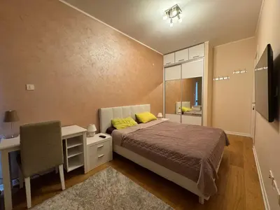 a bedroom with a bed and a desk and a chair at Tre Family in Budva