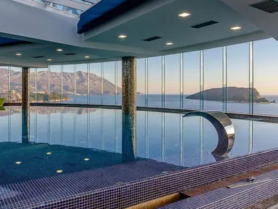 a swimming pool in a building with a view of the water at Tre Family in Budva