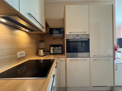 a kitchen with white cabinets and a stove top oven at Tre Family in Budva