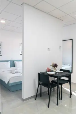 a dining room with a table and a bed at TQ City Apartments in Radanovići