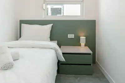 a bedroom with a bed and a table with a lamp at TQ City Apartments in Radanovići