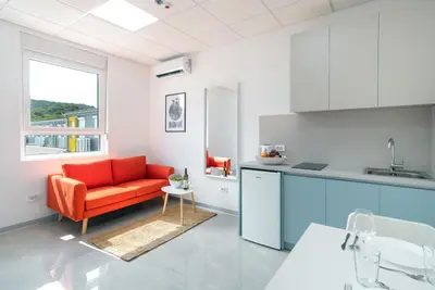 a living room with a red couch in a kitchen at TQ City Apartments in Radanovići