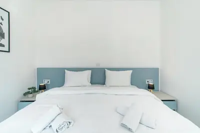 a bedroom with a large white bed with white pillows at TQ City Apartments in Radanovići