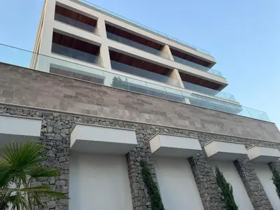 a tall white building with balconies on top of a building at Pine & Sea in Bar