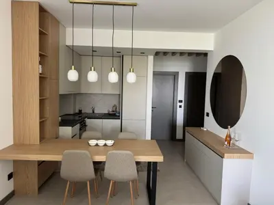 a kitchen and dining room with a wooden table and chairs at Pine & Sea in Bar