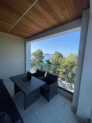 a living room with a table and a couch and a large window at Pine & Sea in Bar