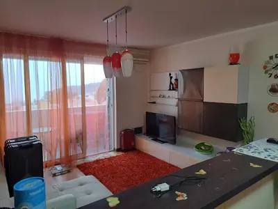 a living room with a television and a kitchen at Apartman More i Nebo in Petrovac na Moru