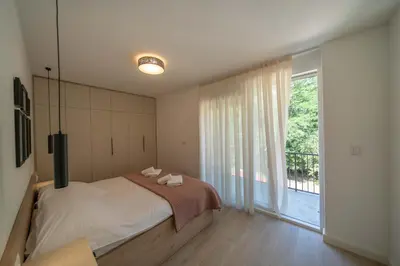 a bedroom with a bed and a large window at Mia Stella in Kotor