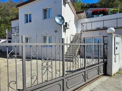 a wrought iron fence in front of a white house at Apartman Stepanović in Budva