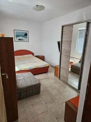 a bedroom with a bed and a large mirror at Apartman Stepanović in Budva