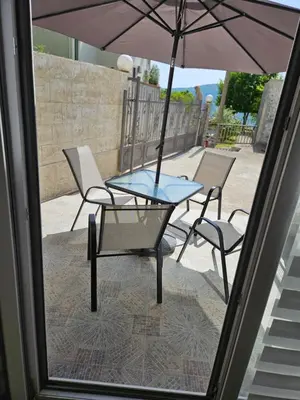 a table and chairs with an umbrella on a patio at Apartman Stepanović in Budva
