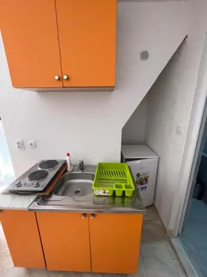 a kitchen with a sink and orange cabinets at Apartmani Ilić in Utjeha