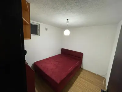 a small room with a red bed in it at Apartmani Ilić in Utjeha