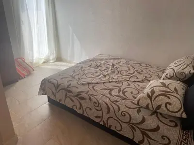 a bed in a room with a blanket on it at Apartmani Ilić in Utjeha