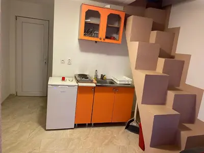 a kitchen with an orange cabinet and a white refrigerator at Apartmani Ilić in Utjeha