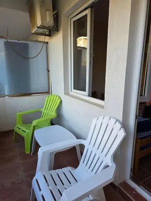 two green and white chairs sitting on a porch at Ekilo in Dobra Voda