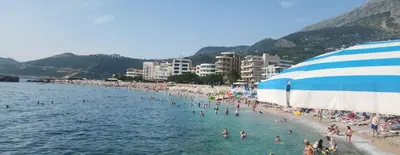 a beach with a bunch of people in the water at Ekilo in Dobra Voda