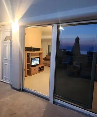 a sliding glass door with a view of a living room at Ekilo in Dobra Voda