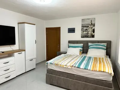 a bedroom with a bed with a flat screen tv at Студия, 800 м до моря in Bar