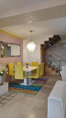 a dining room with a table and yellow chairs at Rezevici AZUR in Budva