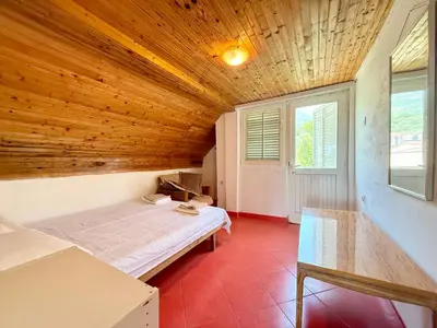 a bedroom with a bed and a wooden ceiling at Dobra Voda Cozy Sea View in Dobra Voda