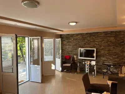 a living room with a tv and a brick wall at Villa Susanj in Bar