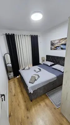 a bedroom with a large bed with black curtains at Lux Star in Ulcinj