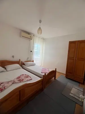 a bedroom with two twin beds and a cabinet at Haus Binas in Ulcinj