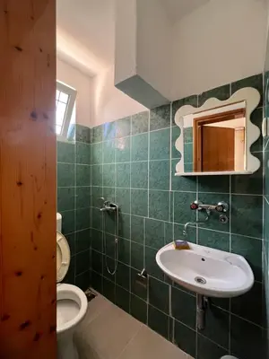 a green tiled bathroom with a sink and a toilet at Haus Binas in Ulcinj